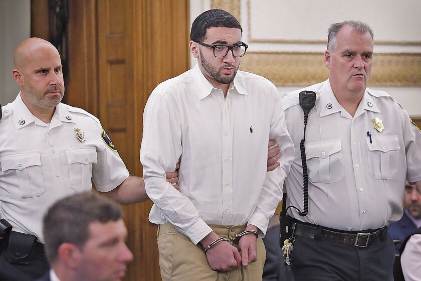 Emanuel "Manny " Lopes is escorted into court on day one of his trial for the 2018 murder of Weymouth Police Sgt. Michael Chesna and Vera Adams, in Norfolk Superior Court in Dedham, Mass., Thursday June 8, 2023. (Greg Derr/The Patriot Ledger via AP, Pool)