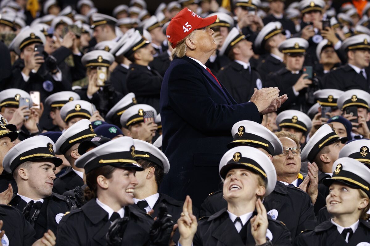 President Trump applauds a flyover while standing on Navy's side of the stadium during halftime Dec. 14, 2019.