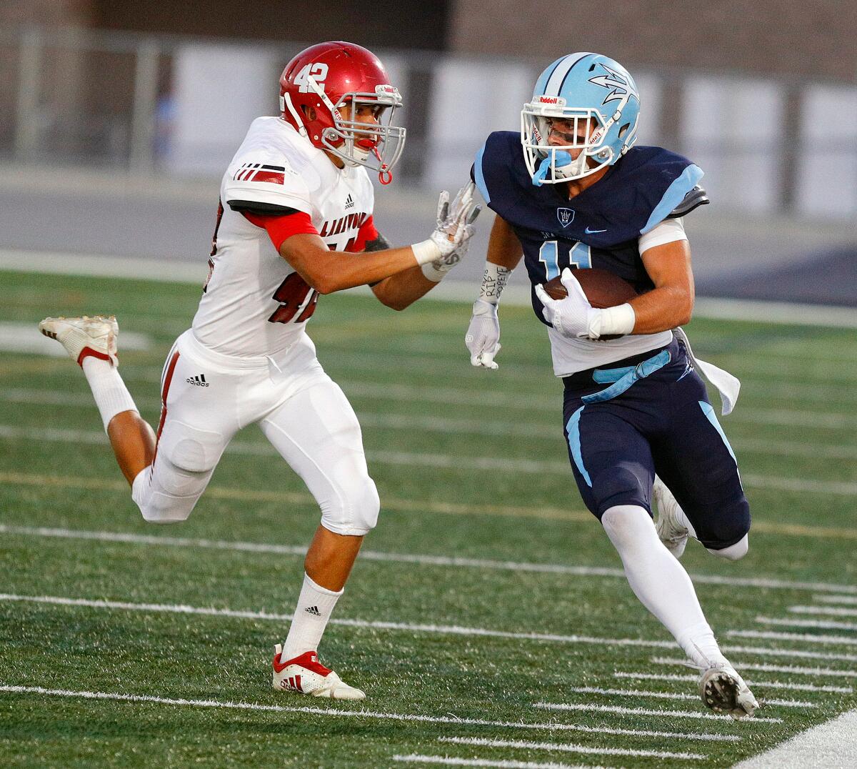 Corona del Mar's Bradley Schlom, pictured running for a first down while Lakewood's Travis Perryman tries to push him out of bounds on Sept. 13, has 11 receiving touchdowns this year.