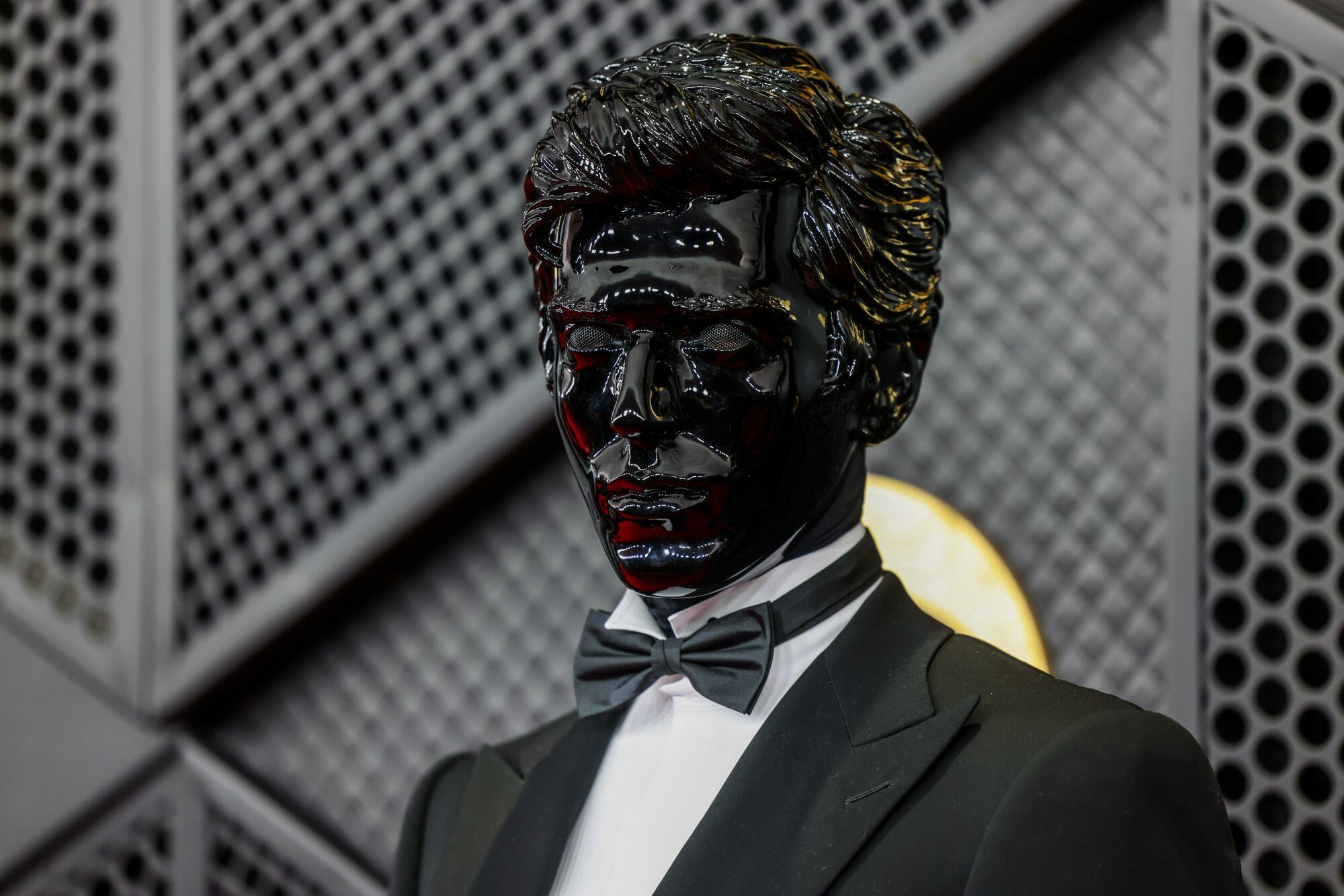 Gesaffelstein, com máscara preta, posa no tapete vermelho.