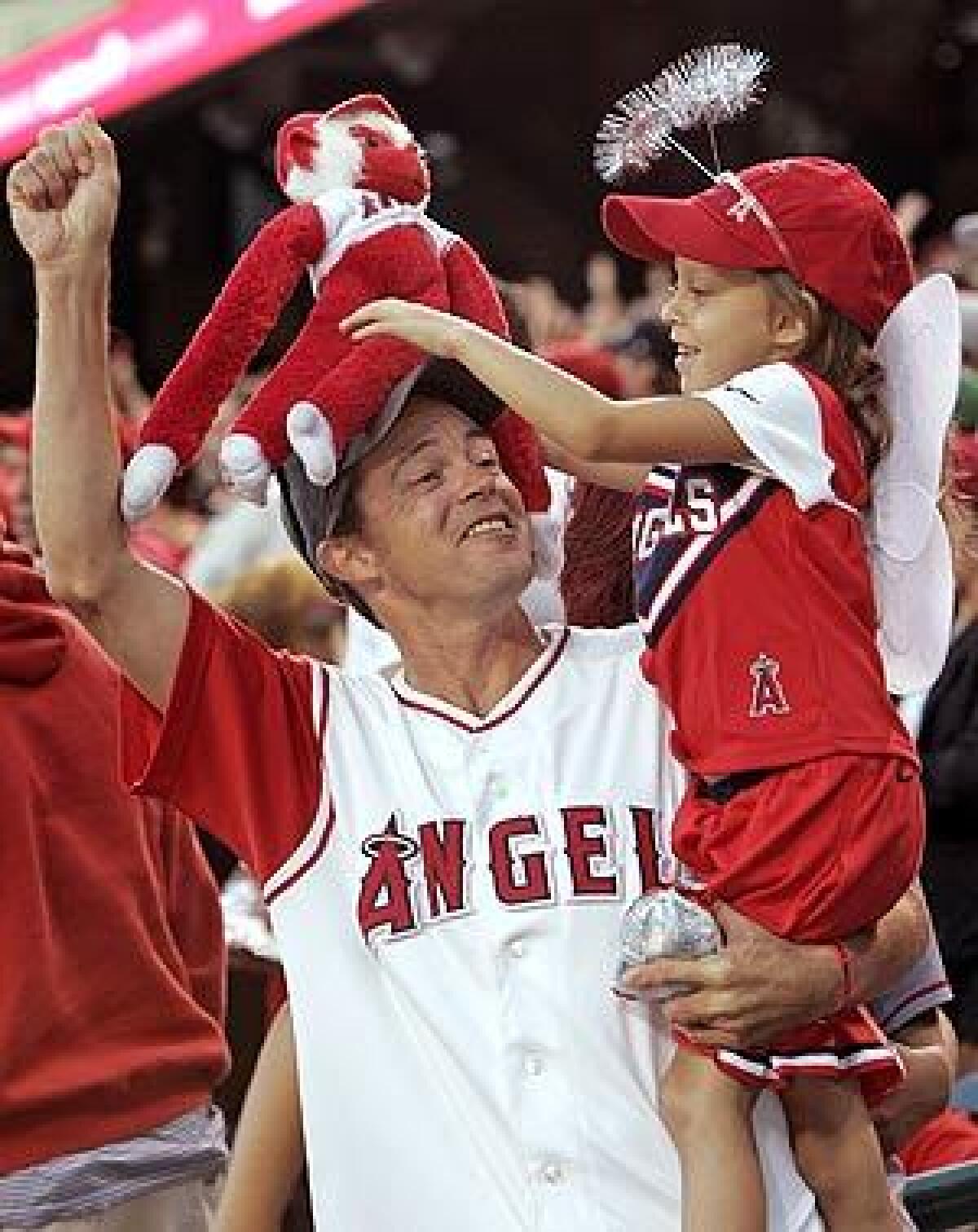 Rob Allen and his daughter, Jayden,7, of Lake Forest at the Angels rally Monday night at Anaheim Stadium.