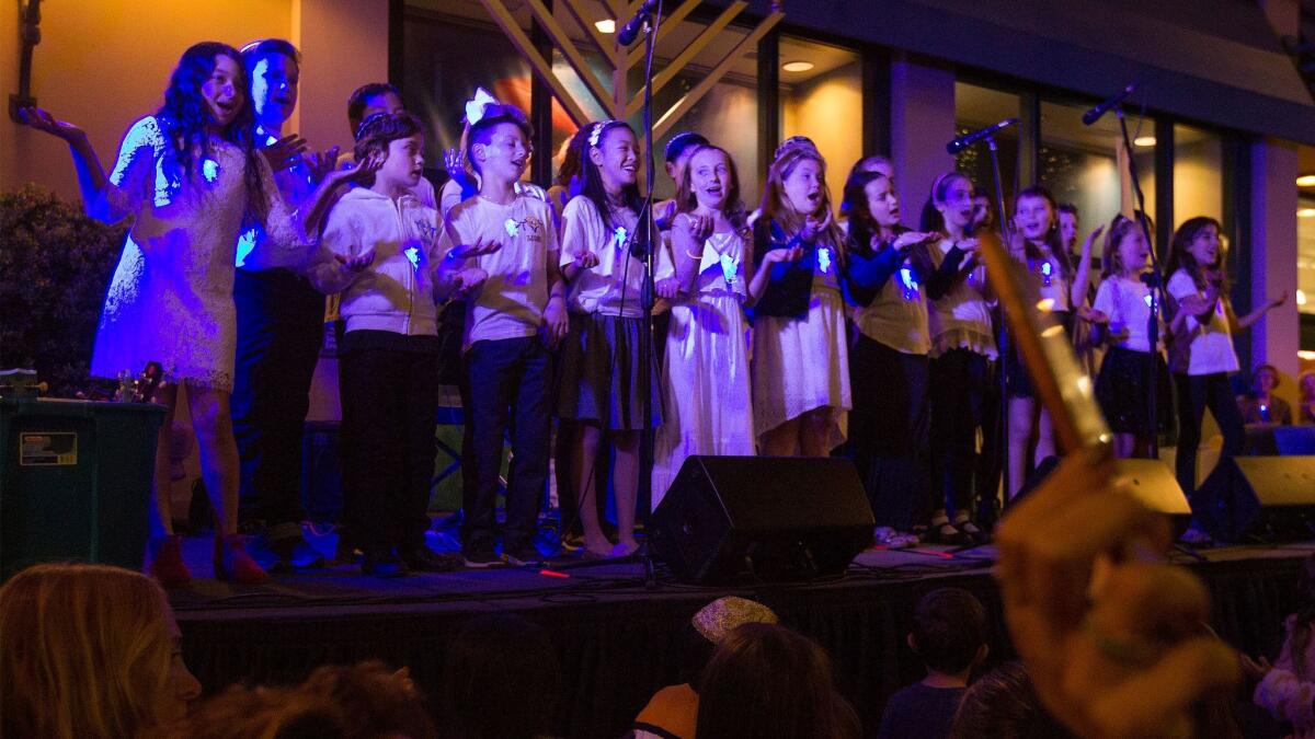 Tarbut V'Torah Childrens Choir sing during the menorah lighting ceremony celebrating the first night of Hanukkah at Fashion Island on Tuesday.