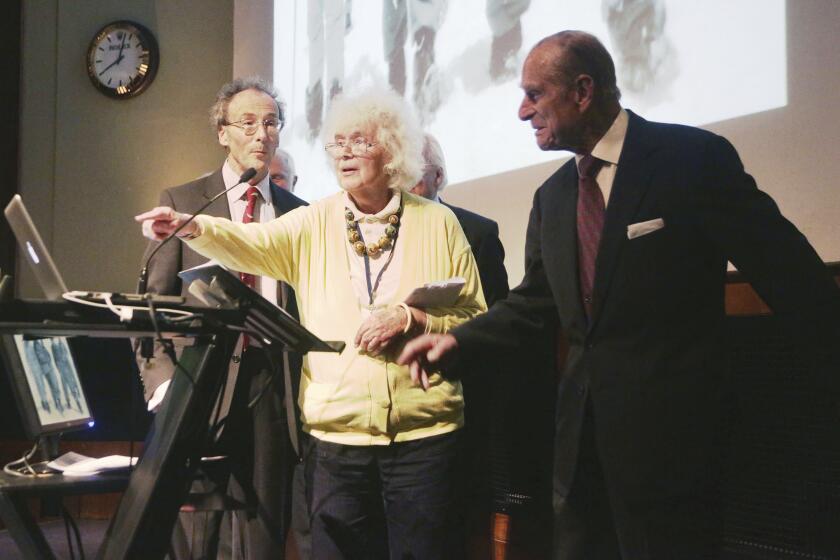 FILE - In this May 29, 2013 file photo, travel writer, journalist and author, Jan Morris, center, with the Duke of Edinburgh, right, during a reception to celebrate the 60th Anniversary of the ascent of Everest, at the Royal Geographical Society in London. Morris, the celebrated journalist, historian, world traveler and fiction writer who became a pioneer of the transgender movement, has died at 94. Her literary representative, United Agents, says Morris died in Wales on Friday, Nov. 20, 2020. (Yui Mok/PA via AP, file)