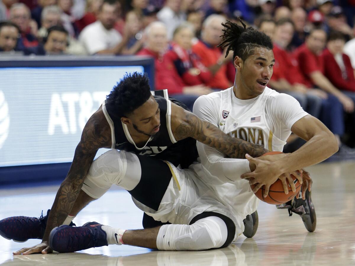Grand Canyon guard Shaq Carr (10) and Arizona forward Keanu Pinder (25) battle for a loose ball during the first half on Dec. 14.