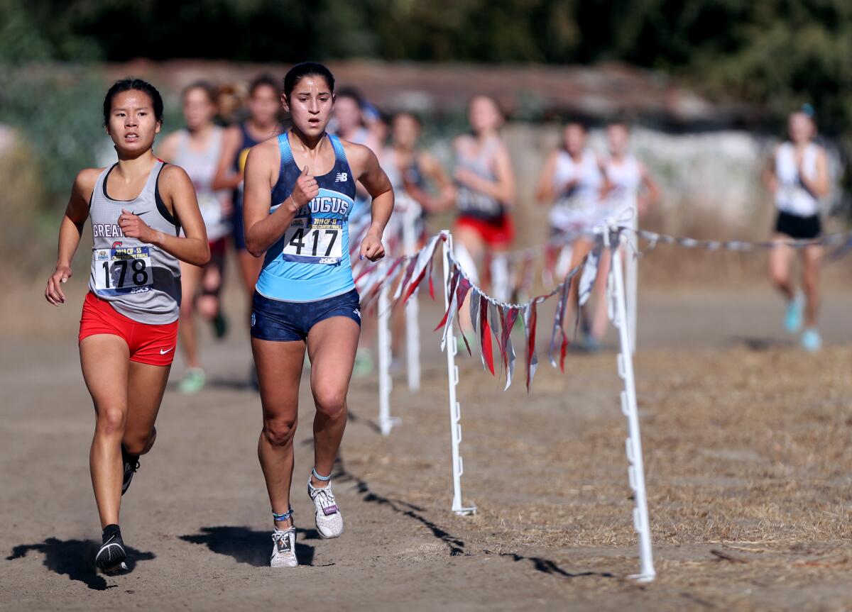 Saugus sophomore Isabella Duarte, right, and Great Oak senior Audrey Dang navigate the Riverside City Cross-Country Course during the Southern Section Division 1 championships on Nov. 23, 2019.