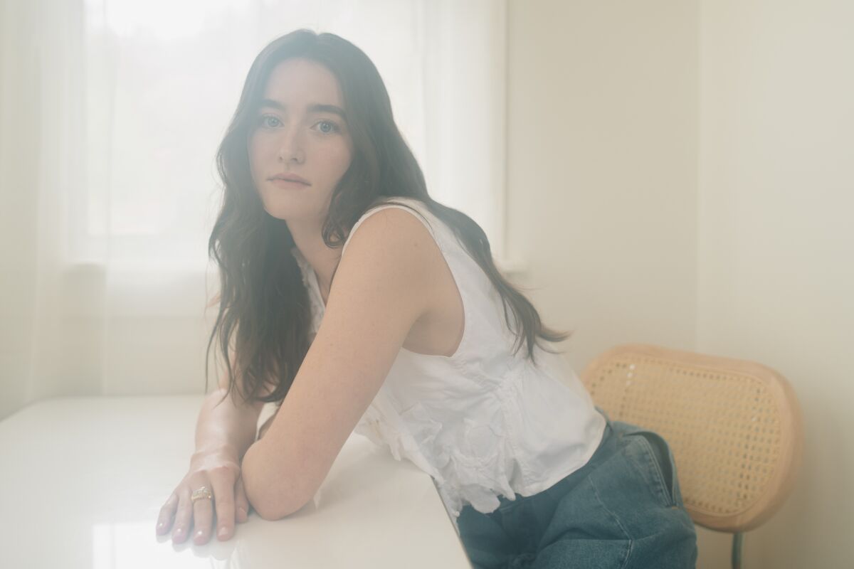 Sarah Pidgeon rests her arms on a table.