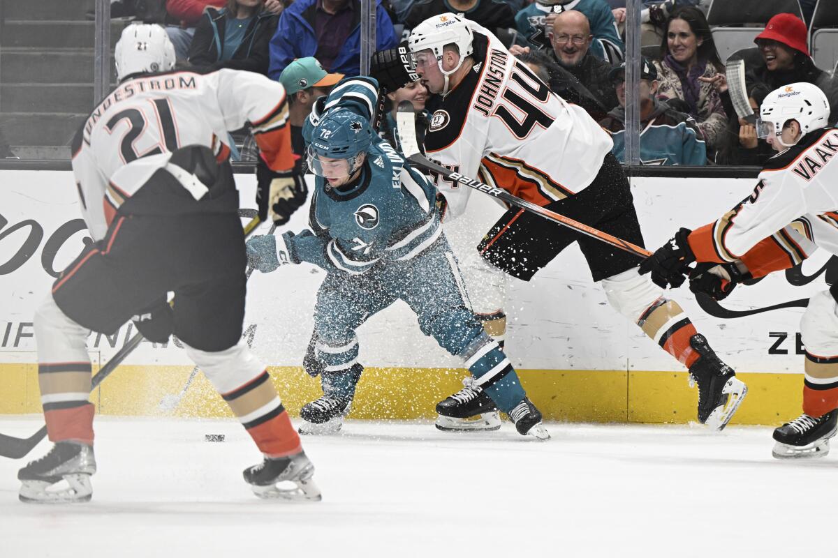 Sharks defenseman Nikolai Knyzhov fights for the puck against Ducks center Isac Lundestrom and left wing Ross Johnston.