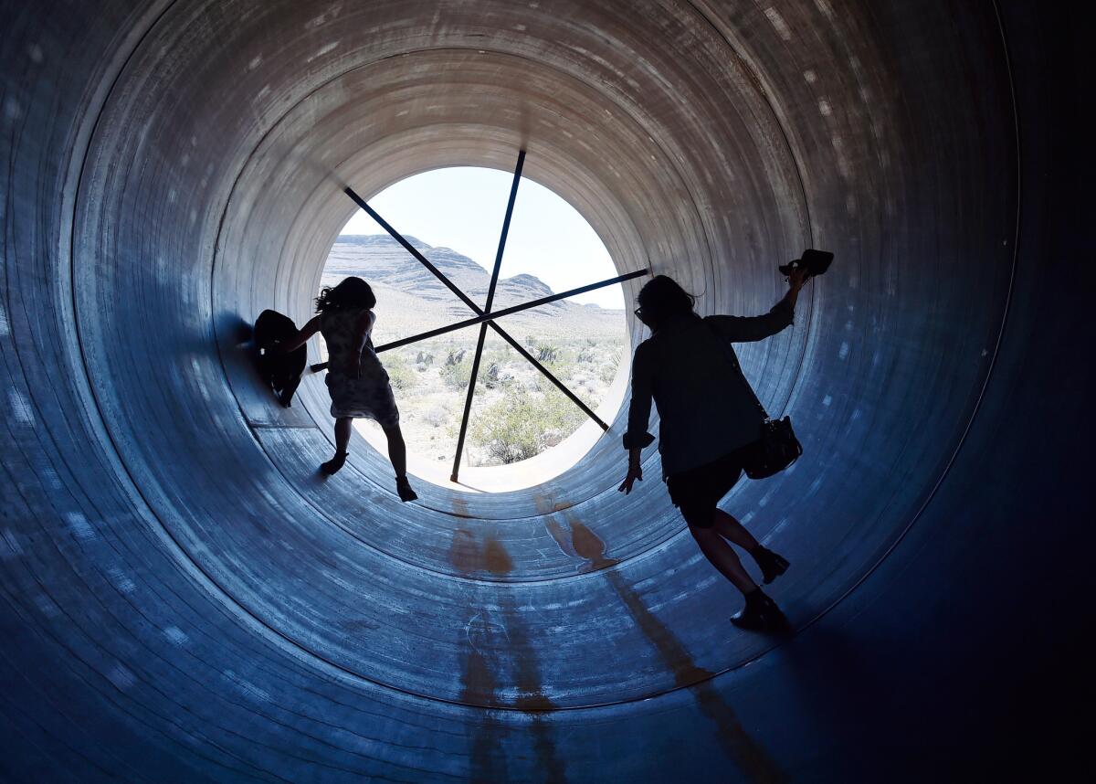People walk through a Hyperloop tube after the first test of a propulsion system.