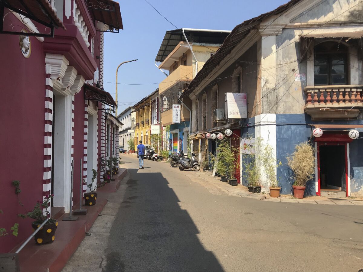 A man walks through a deserted street at Fontainhas, a UNESCO heritage site with Portugese style homes in Panjim, Goa, on Feb. 12, 2022. India's undisputed tourist hot spot, and the tiniest state in the world's largest democracy, is voting Monday to elect a new government with an eye toward restoring an economy ravaged by the pandemic and saving the environment threatened by an unbridled real estate boom. (AP Photo/Vineeta Deepak)