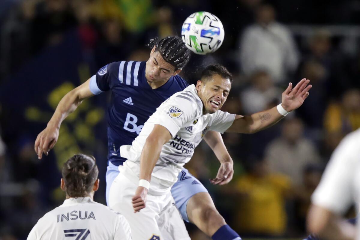 Whitecaps defender Jasser Khmiri and Galaxy forward Javier Hernandez both try to head the ball during the first half of game March 7. 