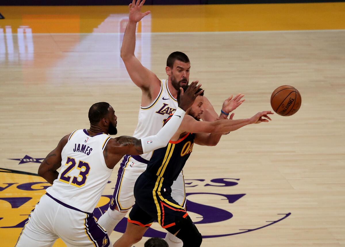 Lakers LeBron James and Marc Gasol try to trap Warriors guard Stephen Curry.