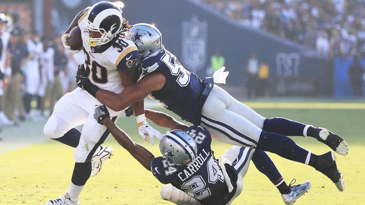 Rams running back Todd Gurley is tackled by Dallas' Damien Wilson (57) and Nolan Carroll (24) during an exhibition game on Saturday.