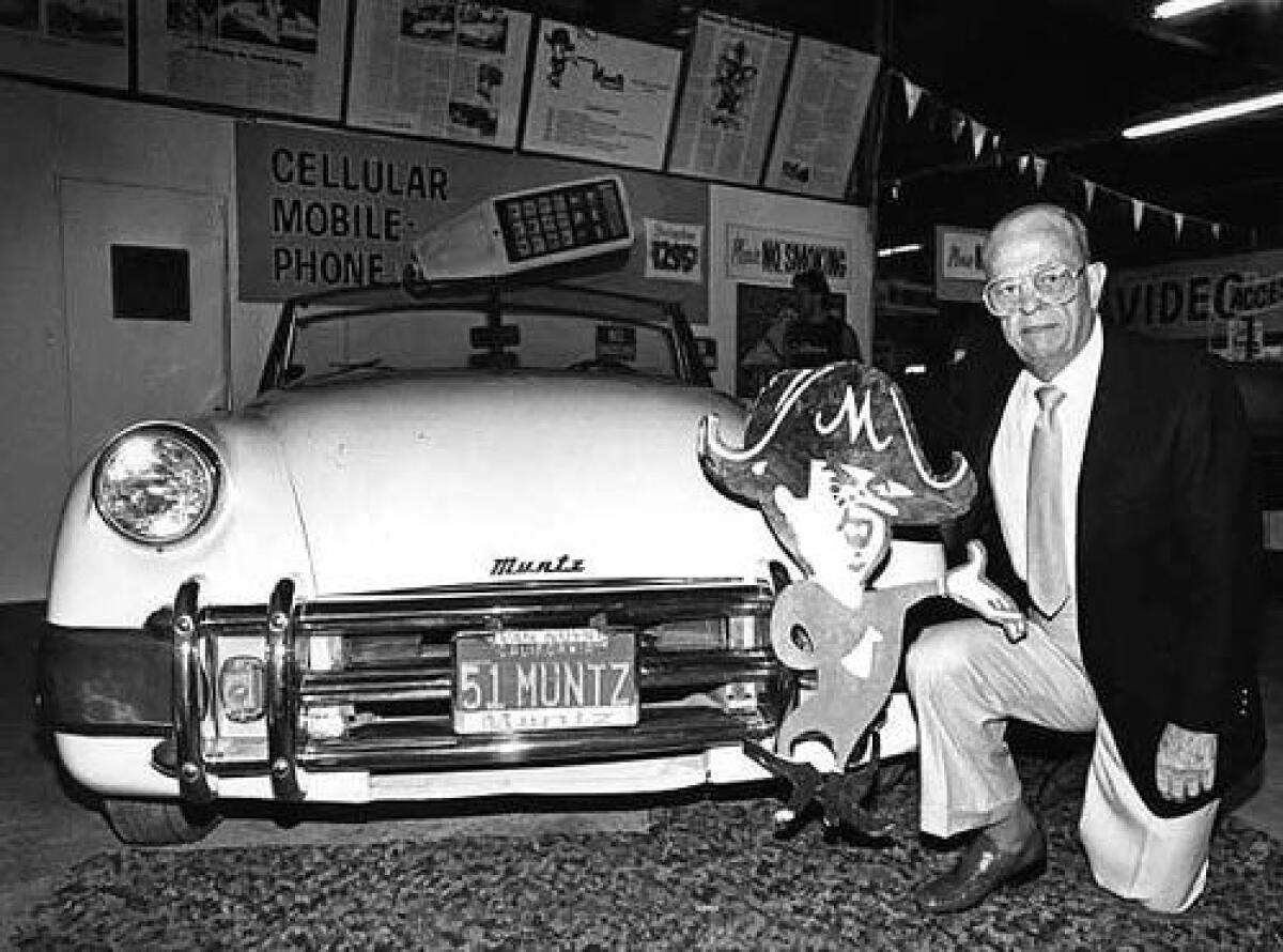 Black and white photo shows a Muntz Jet automobile and Earl Muntz