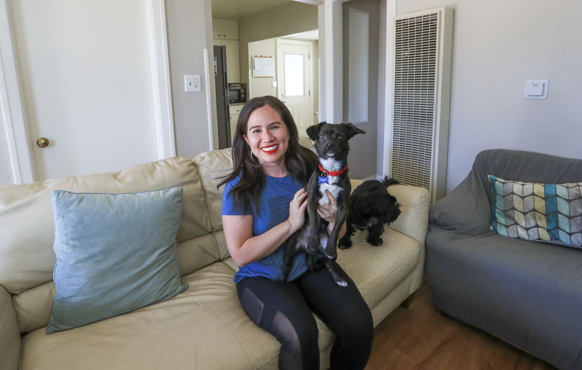 Natalie Hernandez sits with her dogs, Joey and Lea, at her Long Beach home.