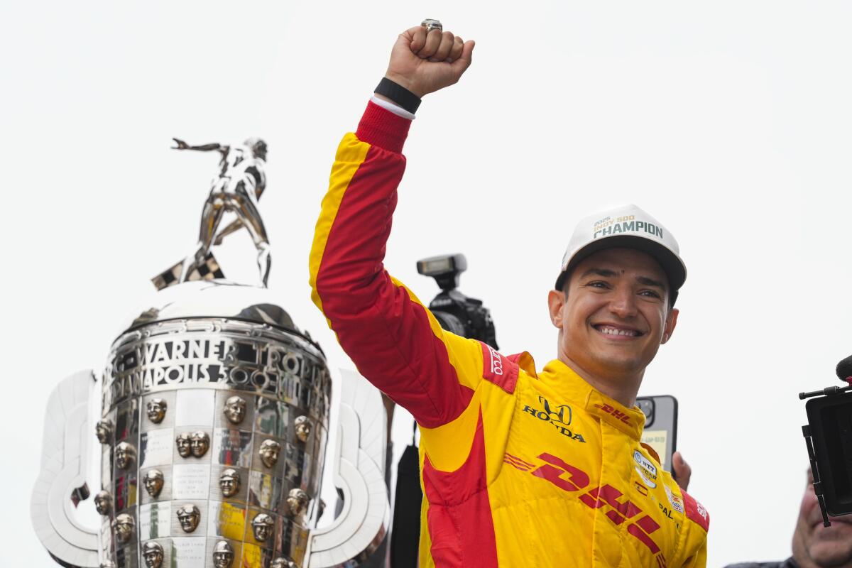 Alex Palou, of Spain, celebrates with fans after winning the In