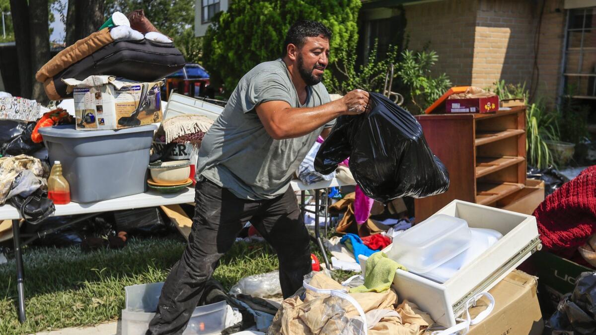 Humberto Romero removes damaged items from his flooded home in the aftermath of Hurricane Harvey in Houston.