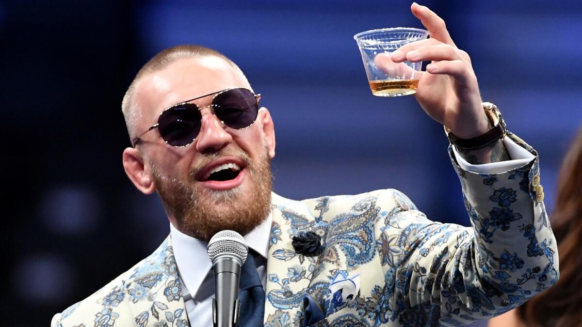 Conor McGregor toasts himself during a news conference after his loss to Floyd Mayweather Jr. in August.