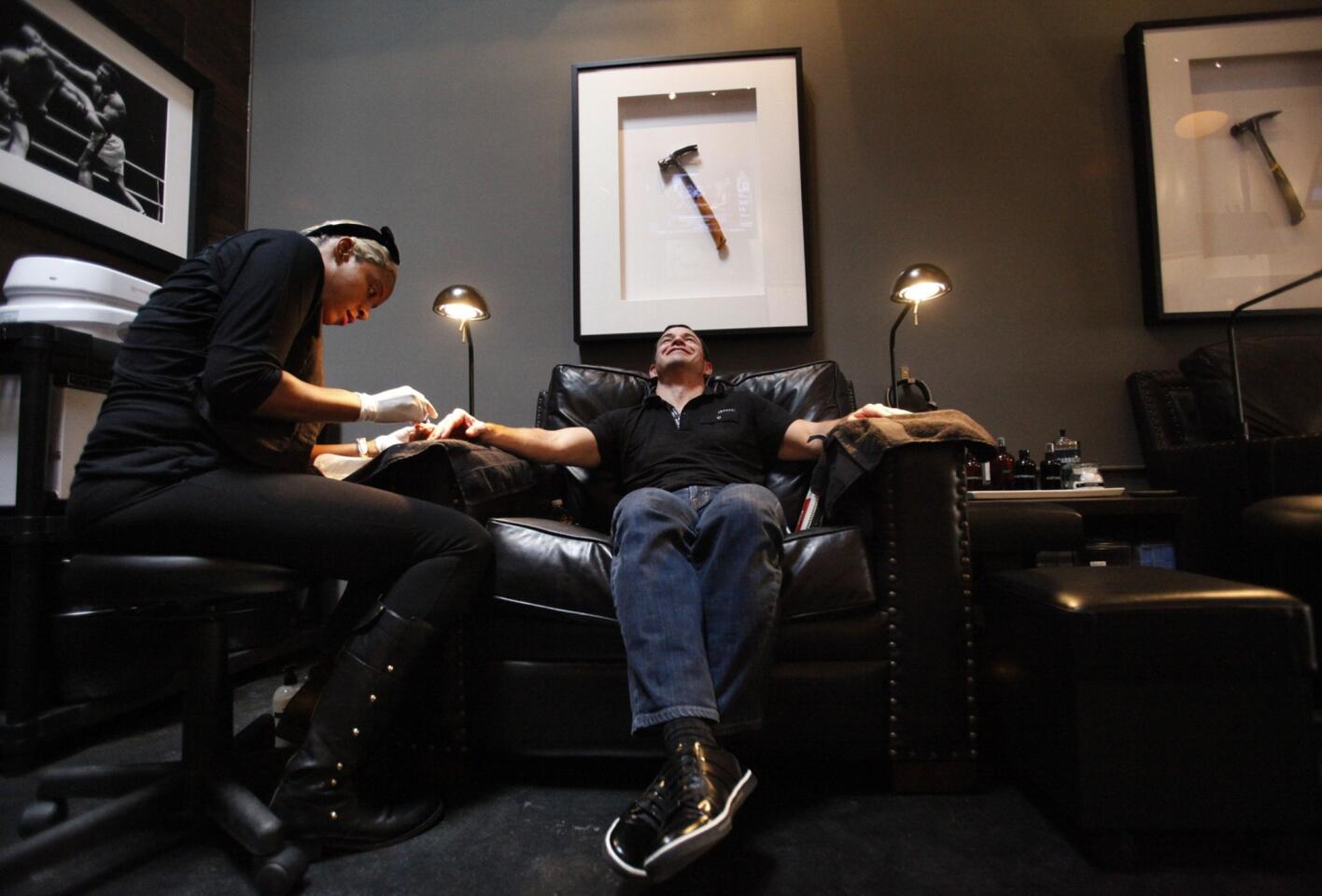 Rick Andreoli has his nails done by Naima Malone at Thursday's media opening for Hammer & Nails, which bills itself as the first nail salon for men in Los Angeles. He is editor-in-chief of knoworthy.com.