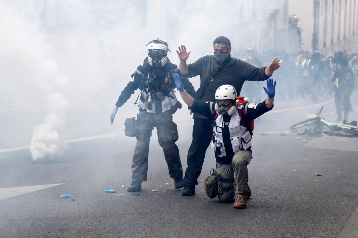 Medics gesture in the street through smoke of tear gas, during a May Day demonstration in Paris. (ZAKARIA ABDELKAFI / AFP / Getty Images )