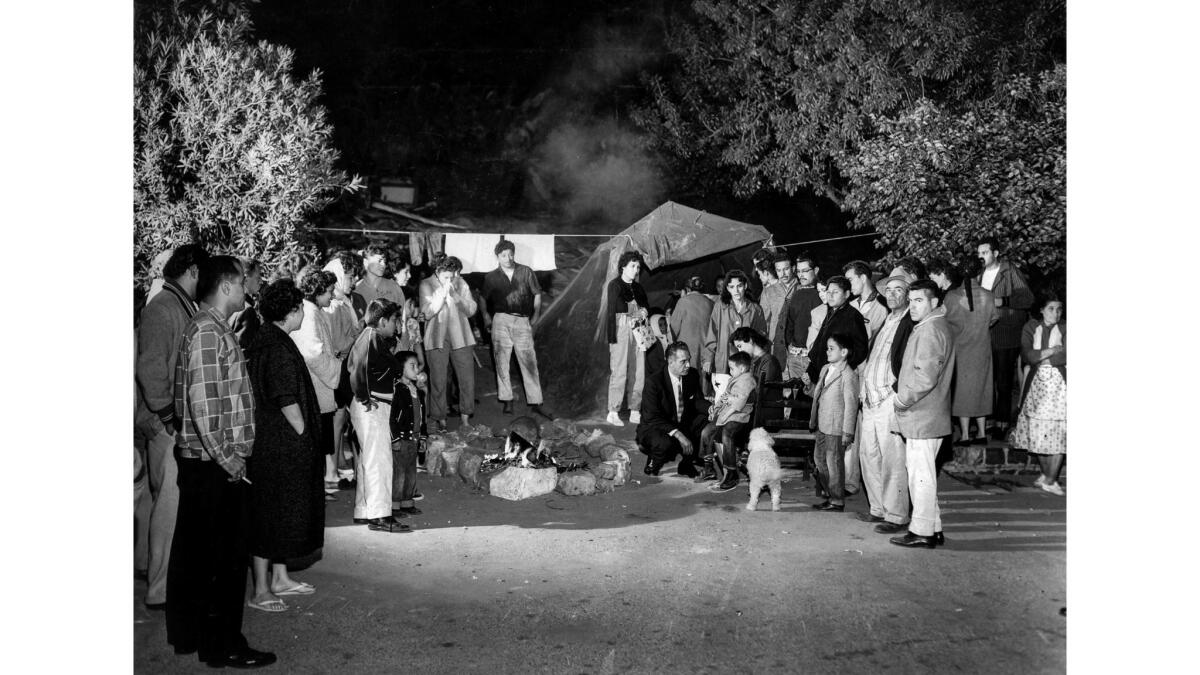 May 8, 1959: Los Angeles City Councilman Edward Roybal, center, talks with members of the Arechiga family, who continued to camp out on the site of their home after it was razed.