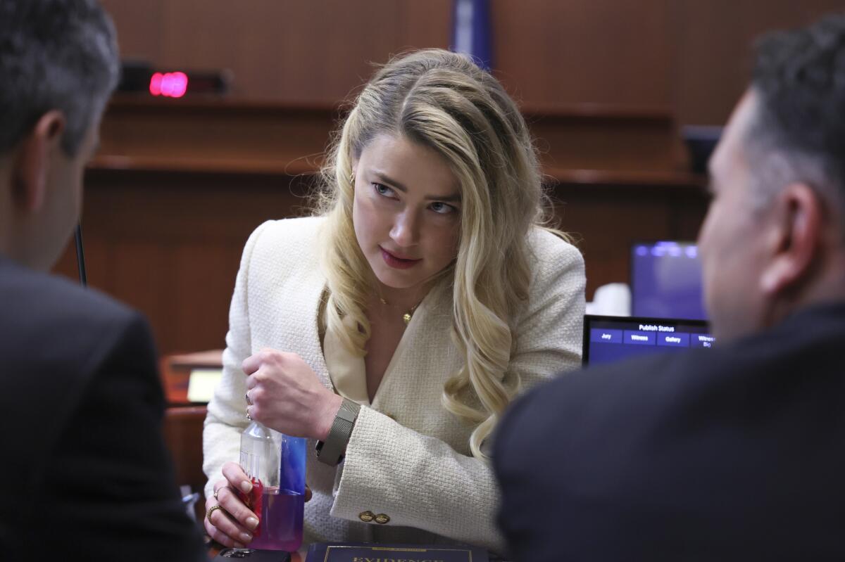 Amber Heard talks to her attorneys in a Virginia courtroom
