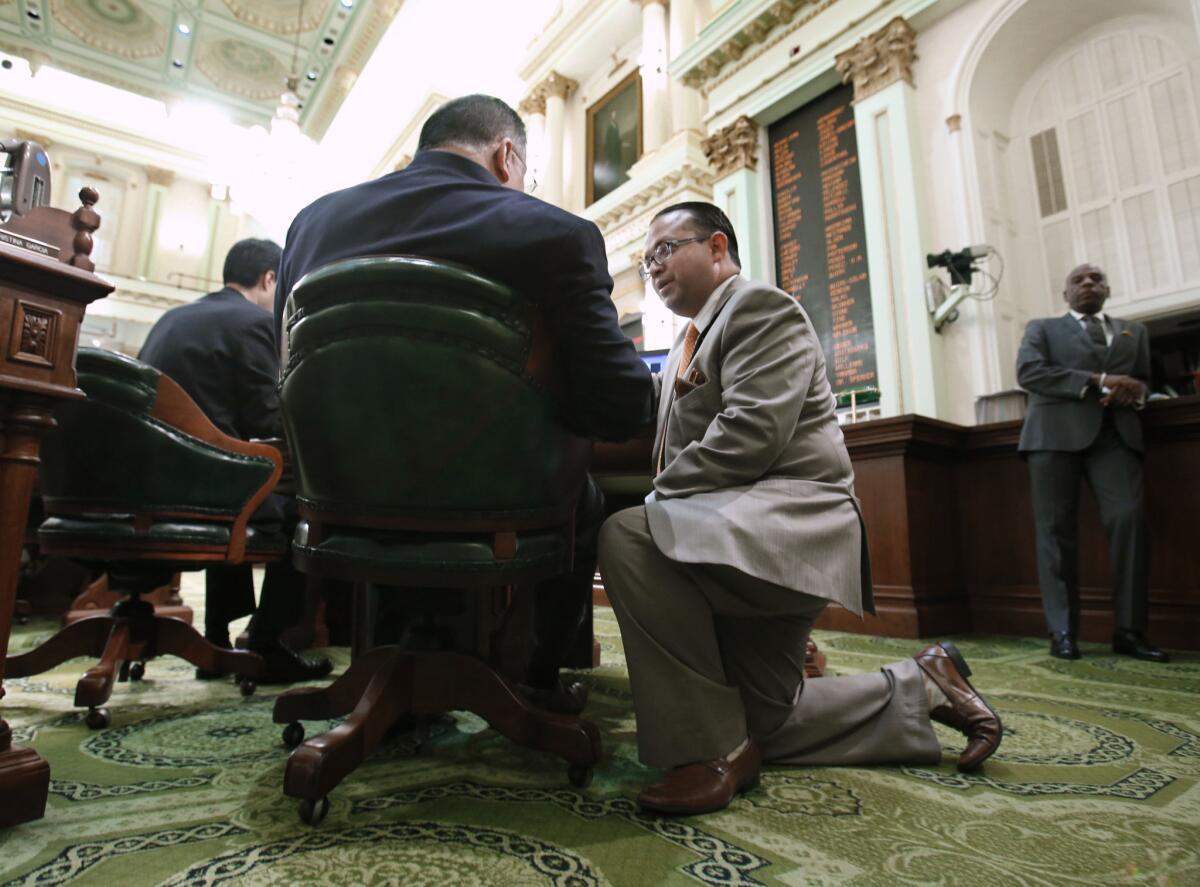 Assemblyman Luis Alejo (D-Watsonville), right, talks with Assemblyman Jose Medina (D-Riverside) during the Assembly session at the Capitol in Sacramento on Tuesday. On Wednesday, Alejo shelved a bill for the year that would provide driver's licenses to immigrants in the country illegally.