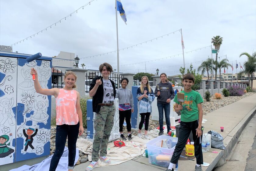 Students from Warren-Walker School get ready to paint designs on utility boxes outside the Portuguese Hall in Point Loma.