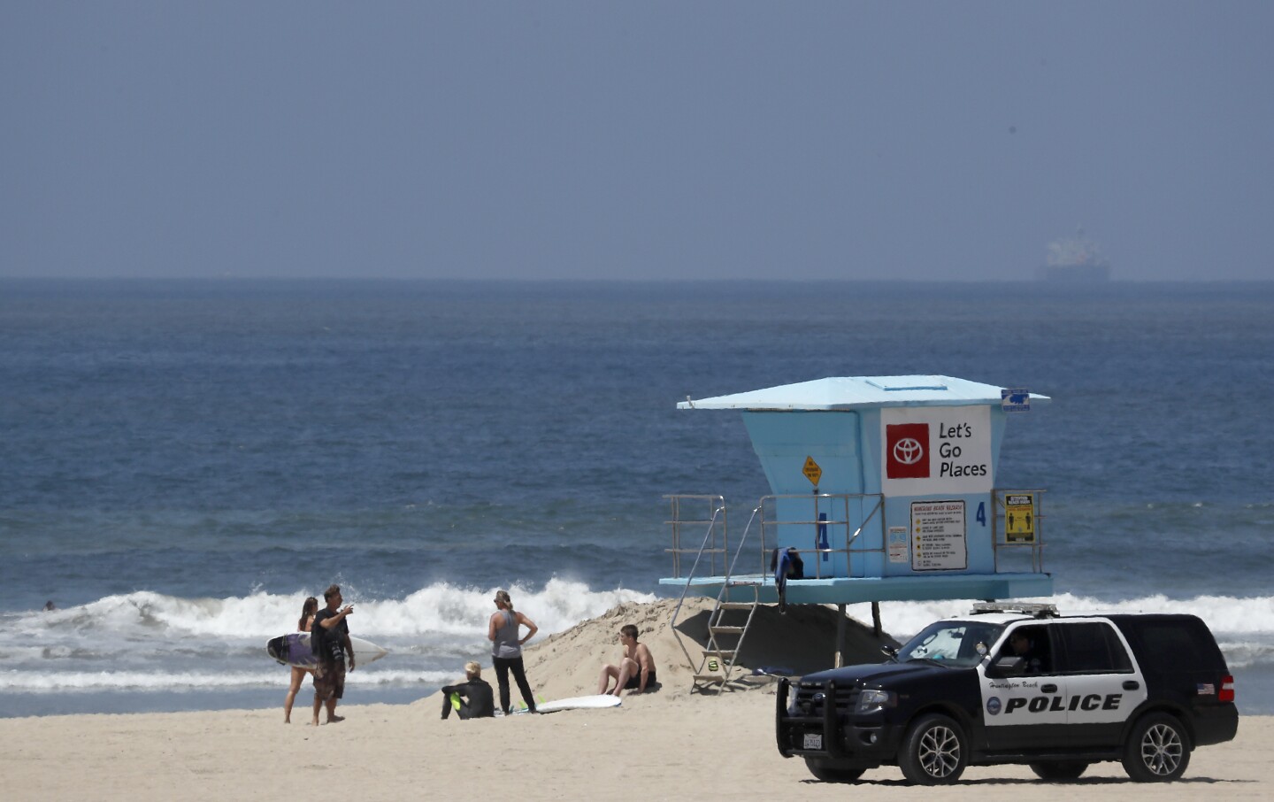 HUNTINGTON BEACH - MAY 2, 2020. A police cruiser patrols near the Huntington Beach Pier on Saturday, May 2, 2020. California Gov. Gavin Newson ordered a hard closure of Orange County beaches this weekend. But responding to public pressure in recent days, Newson has implied that a gradual reopening of beaches, parks and the economy following the coronavirus lockdown could begin as early as next week. (Luis Sinco/Los Angeles Times)