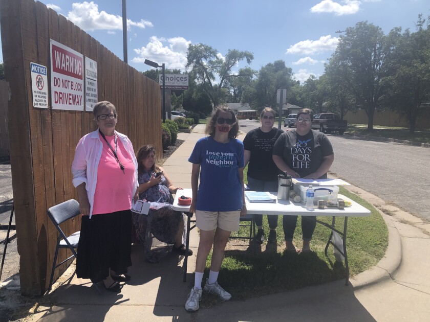 Antiabortion protesters stand near a table