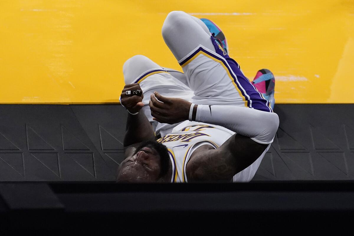 Lakers forward LeBron James rolls off the court after going down with an injury March 20, 2021, in Los Angeles.