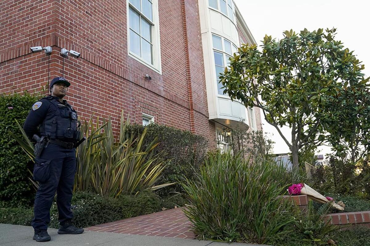 An officer outside a brick house