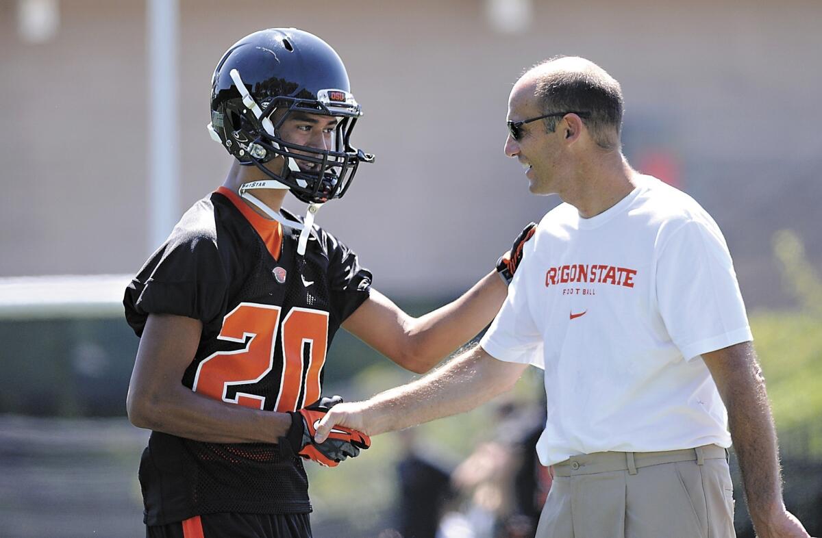 Oregon State coach Mike Riley greets cornerback Chris Hayes during a team practice session Monday. Oregon State is poised to make an impact in the Pac-12 this season.
