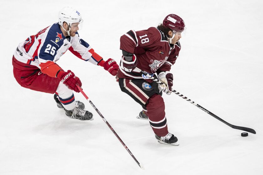 FILE - Moscow's Mikhail Grigorenko, left, fights for the puck against Dinamo's Mathew Maione during the KHL World Games 2018 between Dinamo Riga and CSKA Moscow at the Hallenstadion in Zurich, Switzerland, on Nov. 28, 2018. In a ruling whose details were released Monday, Nov. 28, 2022, New Jersey gambling regulators fined Caesars Sportsbook $500 for wrongly refusing to pay out $27,000 in winnings to a gambler who wagered on a Dec. 22, 2021, game involving Dinamo Riga. The dispute involved whether goals scored in overtime should count toward the bet; the regulators ruled that they should. (Ennio Leanza/Keystone via AP, File)