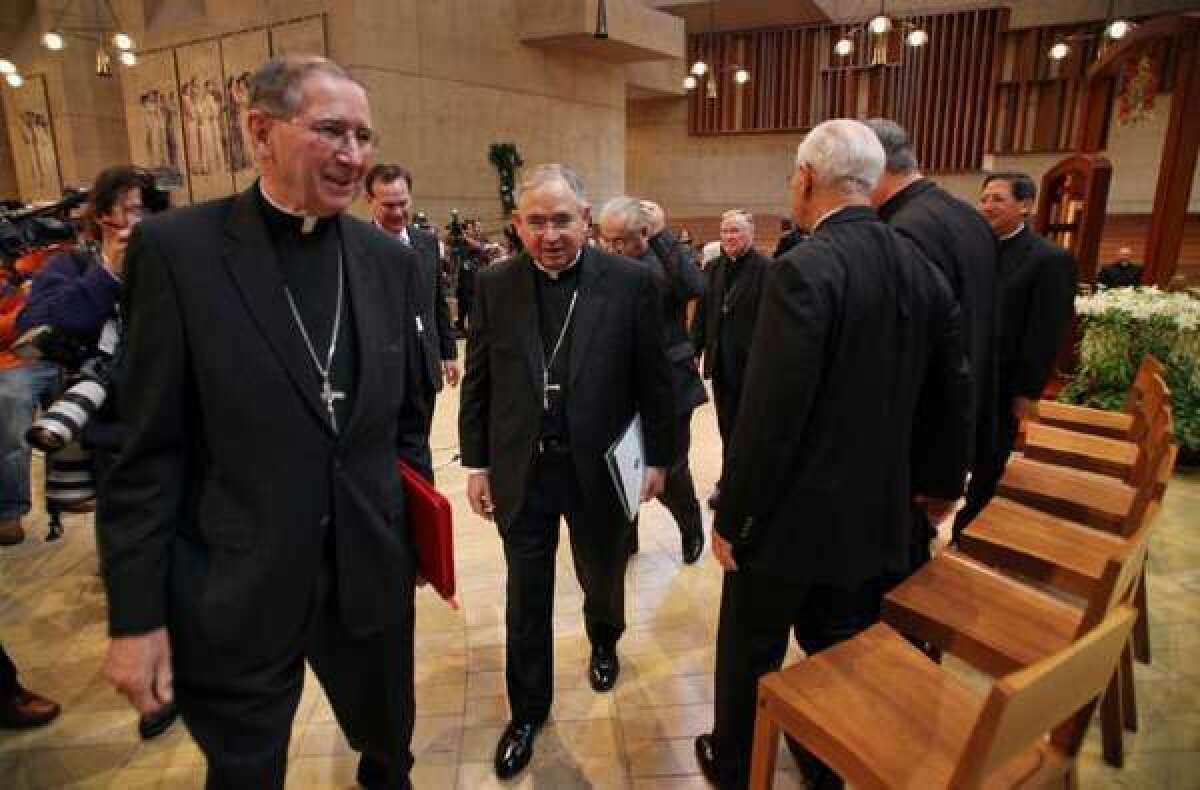 Cardinal Roger Mahony, left, and Archbishop Jose Gomez, who succeeded him as head of the Los Angeles Archdiocese, depart a press conference at the Cathedral of Our Lady of the Angels today.