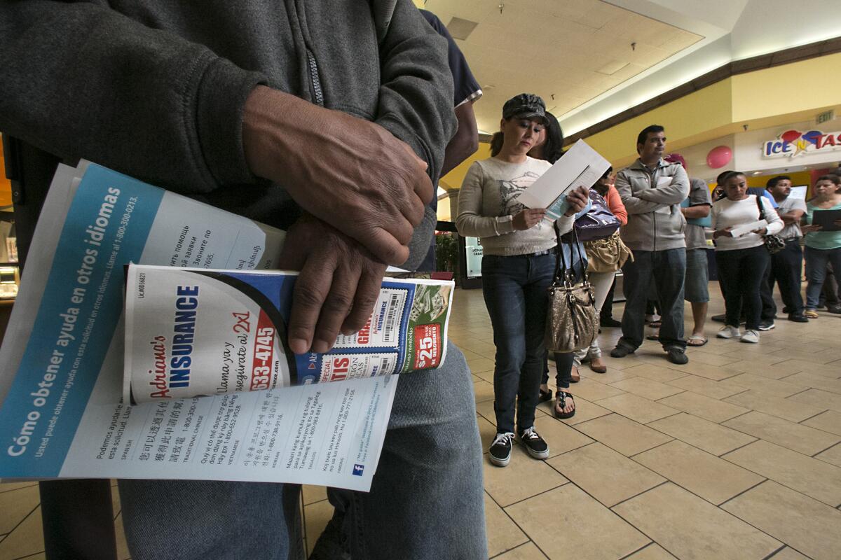 Applicants stand in line at Panorama Mall in Panorama City to sign-up for Covered California at an enrollment event Friday.