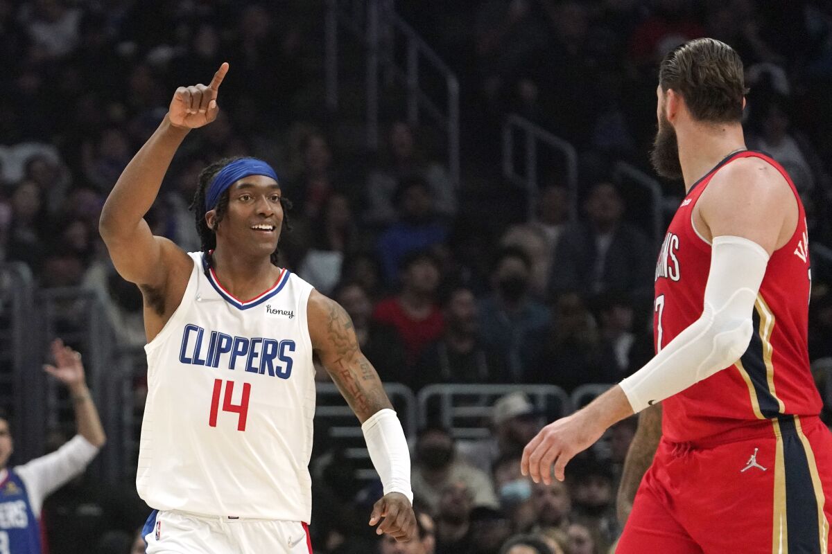 Los Angeles Clippers guard Terance Mann, left, celebrates after scoring as New Orleans Pelicans center Jonas Valanciunas looks on during the first half of an NBA basketball game Sunday, April 3, 2022, in Los Angeles. (AP Photo/Mark J. Terrill)