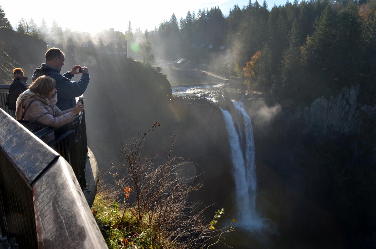 Visitors photograph Snoqualmie Falls, a 270-foot-high waterfall east of Seattle. Members of the Snoqualmie tribe believe that mist rising from the falls lifts their prayers.