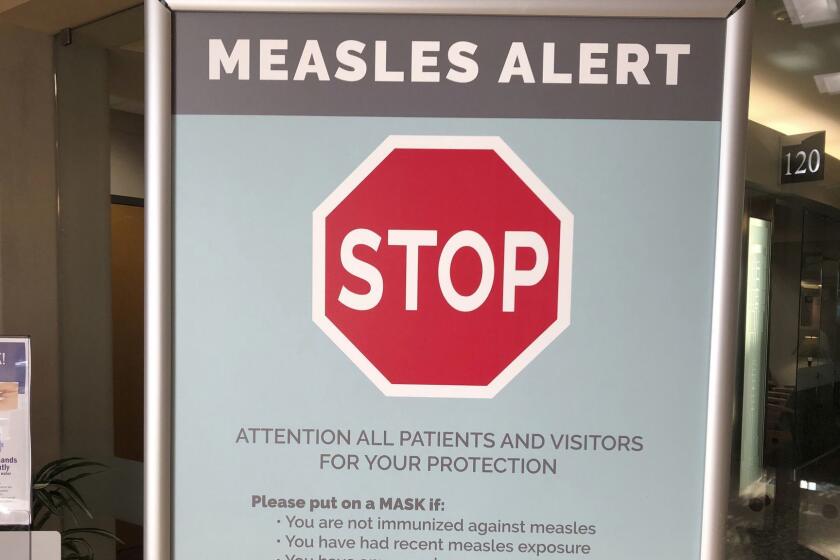 FILE - In this Jan. 30, 2019, file photo, a sign warning patients and visitors of a measles outbreak is shown posted at The Vancouver Clinic in Vancouver, Wash. Officials in the Pacific Northwest say a measles outbreak that sickened multiple people is over. (AP Photo/Gillian Flaccus, File)