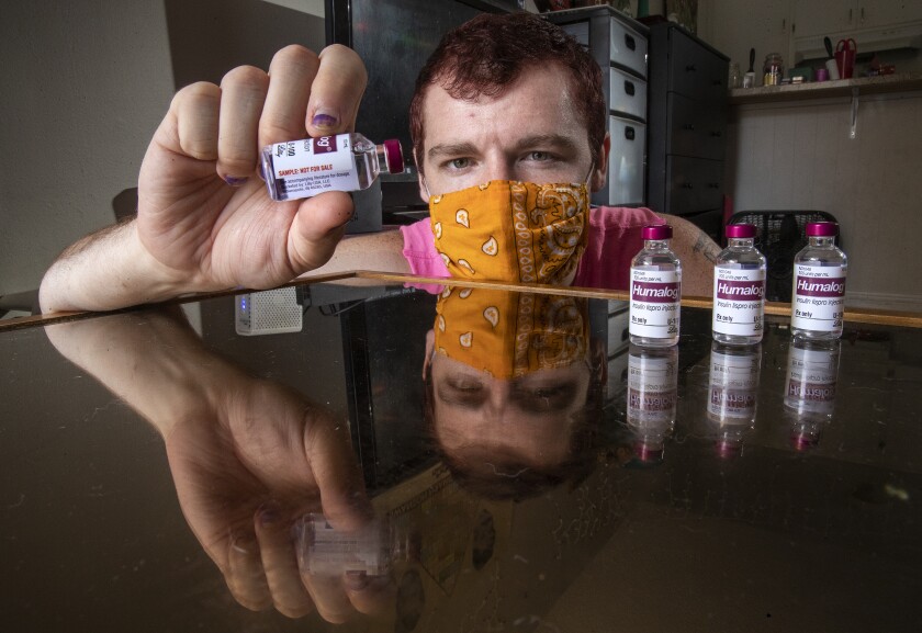 Adam Winney, paciente diabético, con frascos de muestra de insulina que le entrega su médico. 