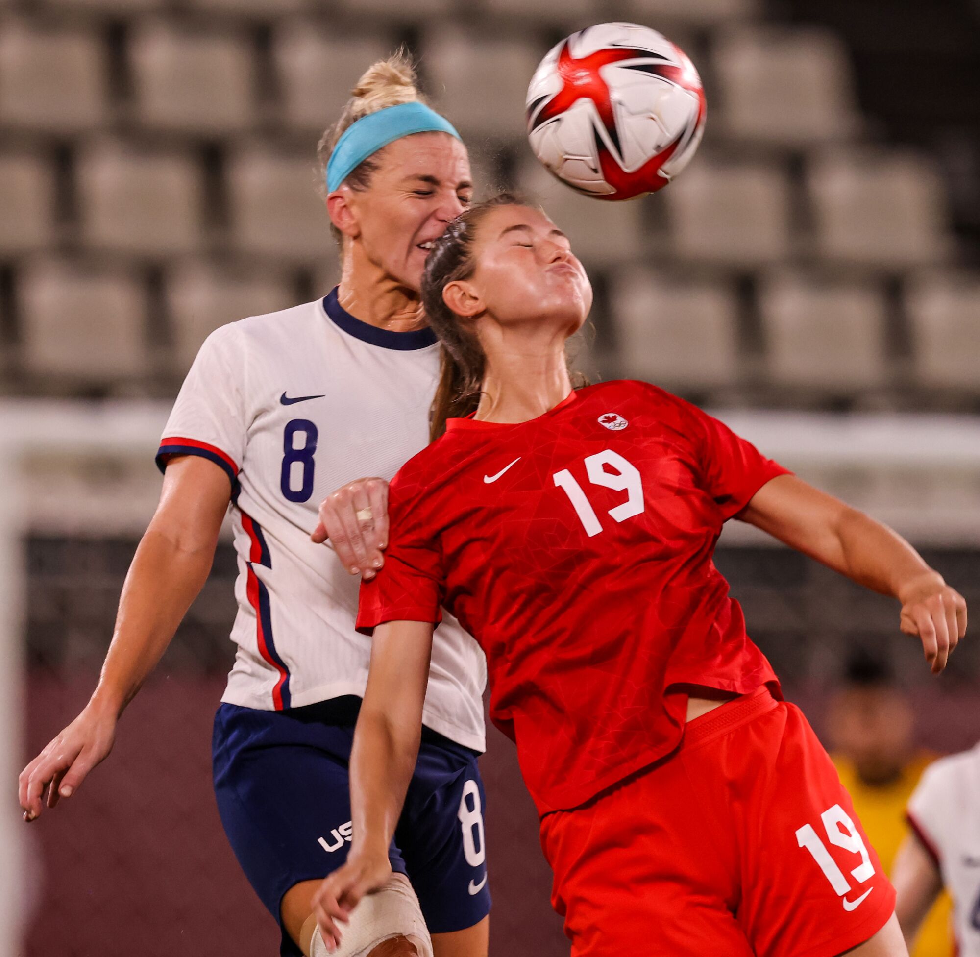 Julie Ertz is knocked in the face by the back of Canada forward Jordyn Huitema's head as the ball is in midair.