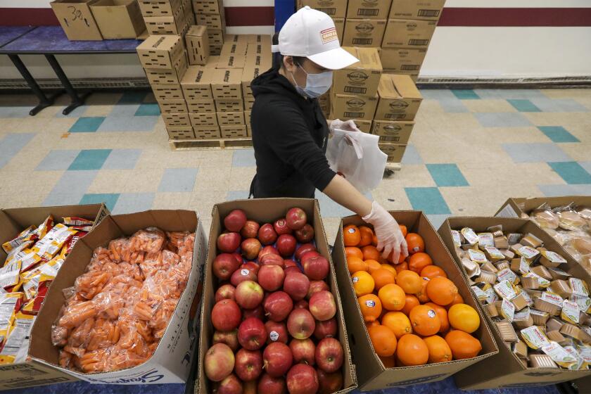 LOS ANGELES, CA - APRIL 21: LAUSD cafeteria crew gets busy in making food bags James A. Garfield High School for distribution among area families. Los Angeles, CA. (Irfan Khan / Los Angeles Times)