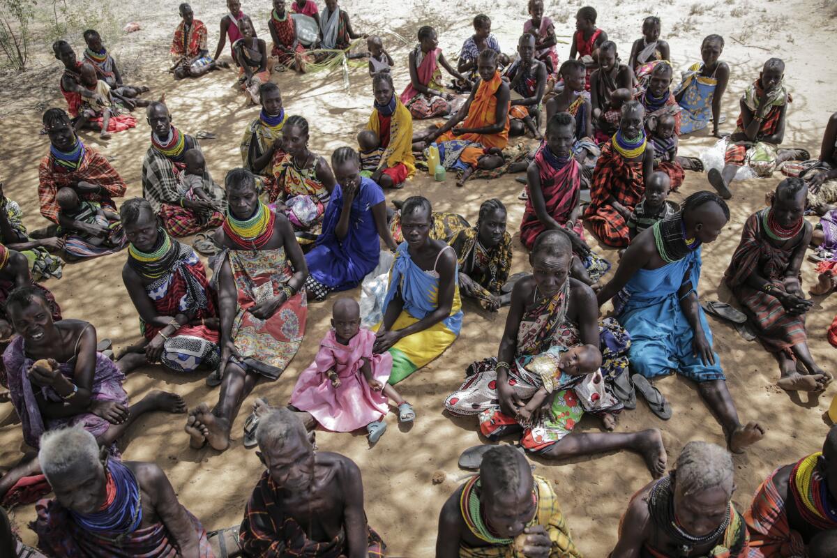 Men, women and children sitting.