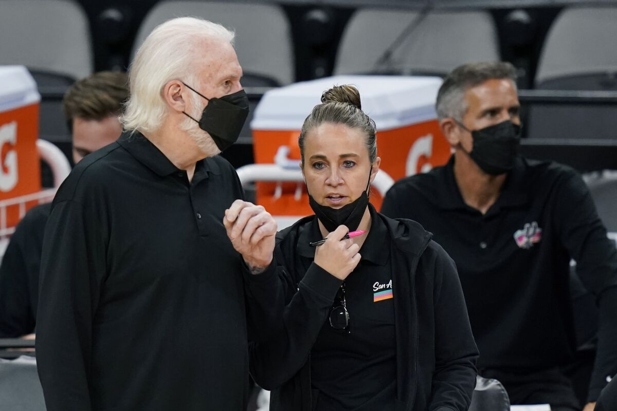 FILE - San Antonio Spurs head coach Gregg Popovich, left, talks with assistant coach Becky Hammon during the second half of an NBA basketball game against the Orlando Magic in San Antonio, in this Friday, March 12, 2021, file photo. Hammon can't wait for the time when it's the norm for females to interview for head coaching positions in the NBA and their gender isn't the story. Hammon's entering her eighth season as an assistant and has been interviewed for several head coach positions but hasn't gotten an offer yet to be the first female to lead a NBA team. (AP Photo/Eric Gay, File)