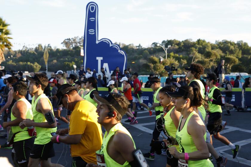 Runners cross the starting line at Dodger Stadium during the L.A. Marathon