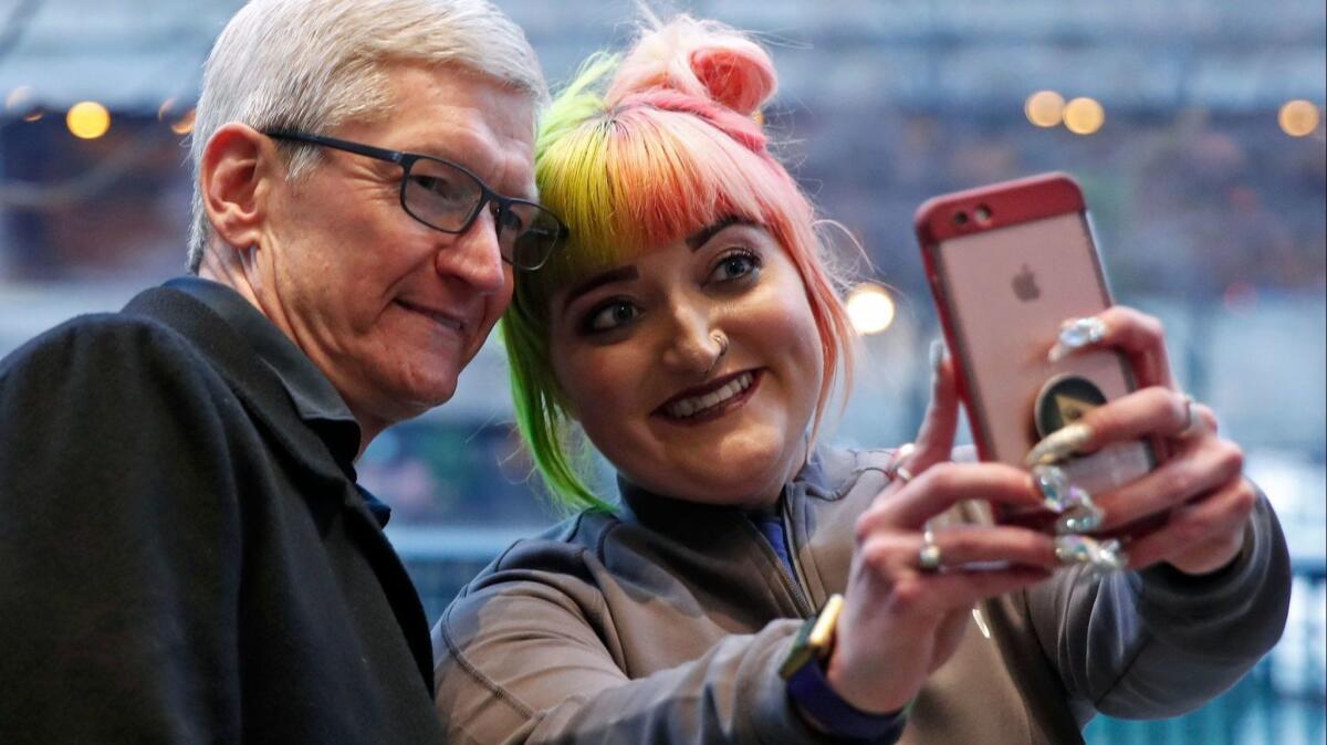 Apple CEO Tim Cook poses for a selfie while visiting an Apple store in Chicago. The company said it is making it easier for users to monitor and control their personal information.