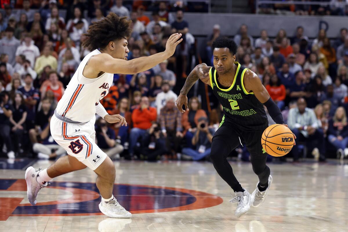 South Florida guard Tyler Harris (2) dribbles the ball as Auburn guard Tre Donaldson (3) defends during the first half of an NCAA college basketball game Friday, Nov. 11, 2022, in Auburn, Ala. (AP Photo/Butch Dill)