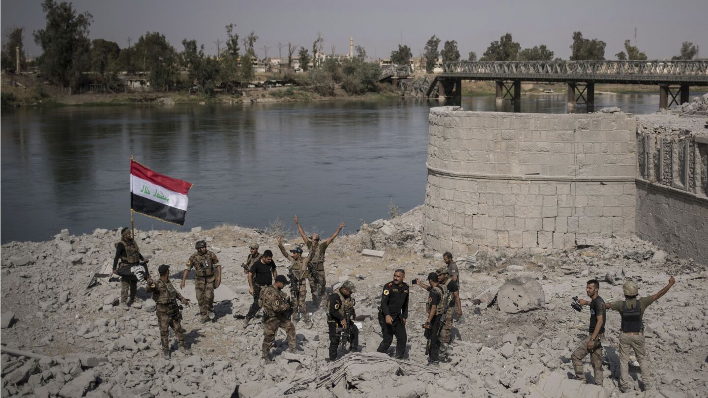 Iraqi Special Forces soldiers celebrate after reaching the bank of the Tigris River.