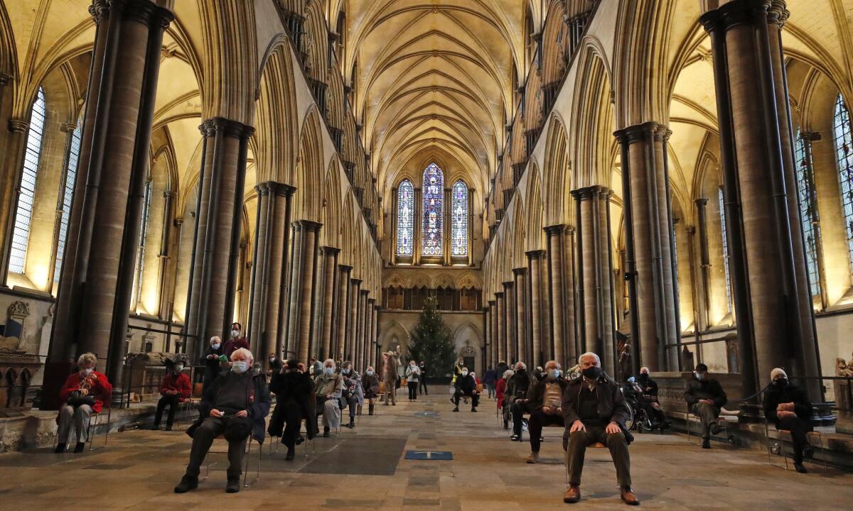 People sit and relax after receiving their Pfizer-BioNTech vaccination at Salisbury Cathedral in Salisbury, England