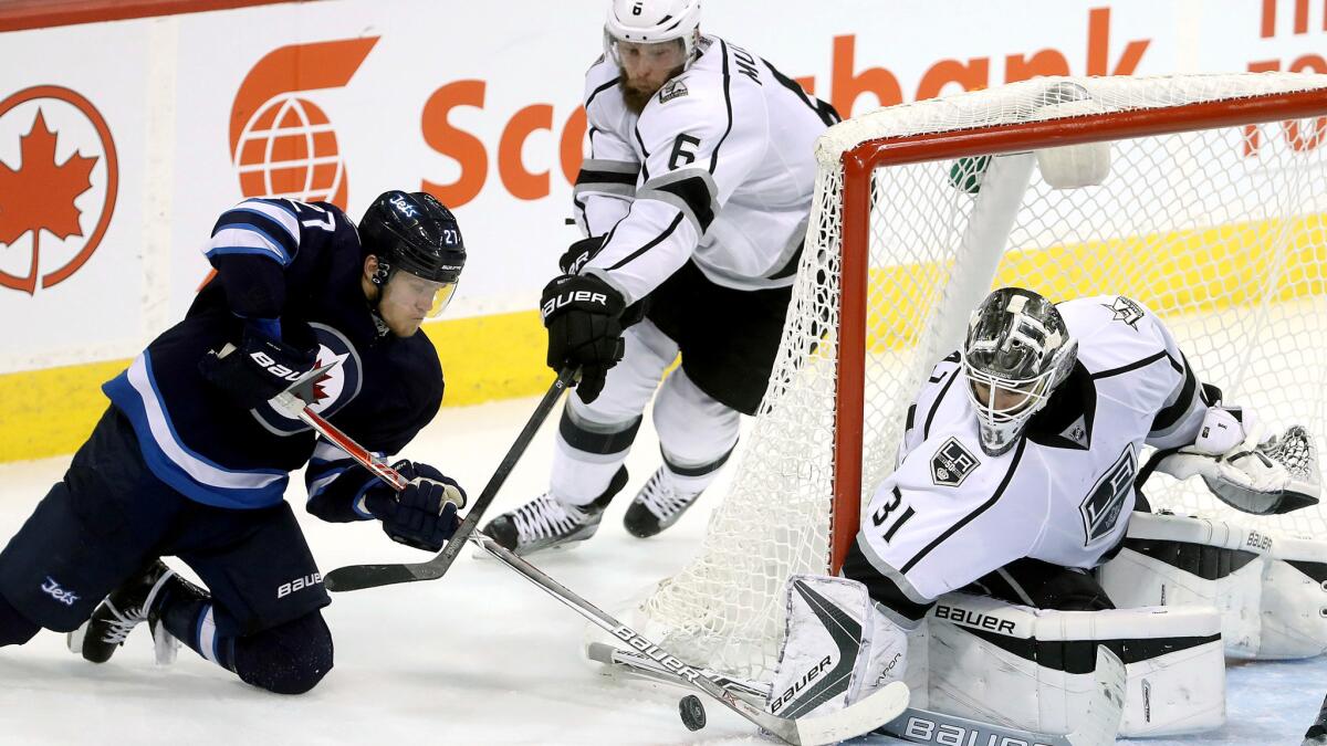 Kings goaltender Peter Budaj stops a wraparound shot by the Jets' Nikolaj Ehlers during the third period Sunday.