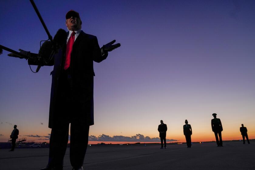 President Donald Trump speaks to reporters as he arrives at Charlotte Douglas International Airport in Charlotte, N.C., to head to a campaign rally at Hickory Regional Airport, Sunday, Nov. 1, 2020. (AP Photo/Evan Vucci)